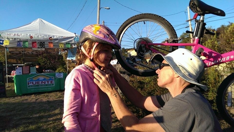 Every helps a young rider with her helmet.