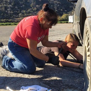 Charlea helps a student change a tire.